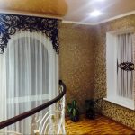Ажурний ламбрекен та білий тюль на сходовому вікні приватного будинку