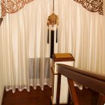 Тюль з ажурним ламбрекеном на сходовому вікні приватного будинку